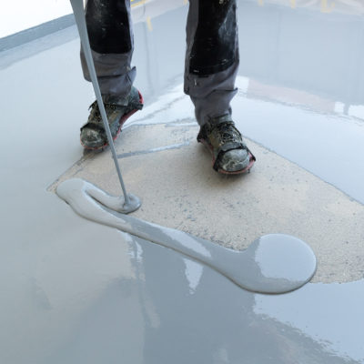 Construction Worker Renovates Balcony Floor And Pours Watertight
